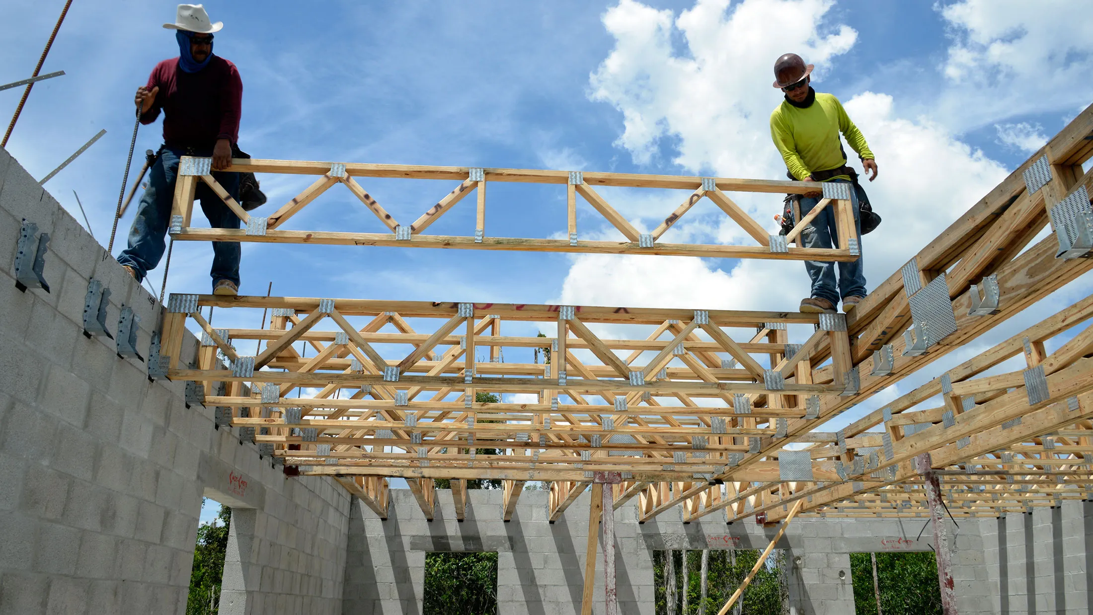 Home builders set floor trusses in place that will support the second story floor in Doral, Florida.
