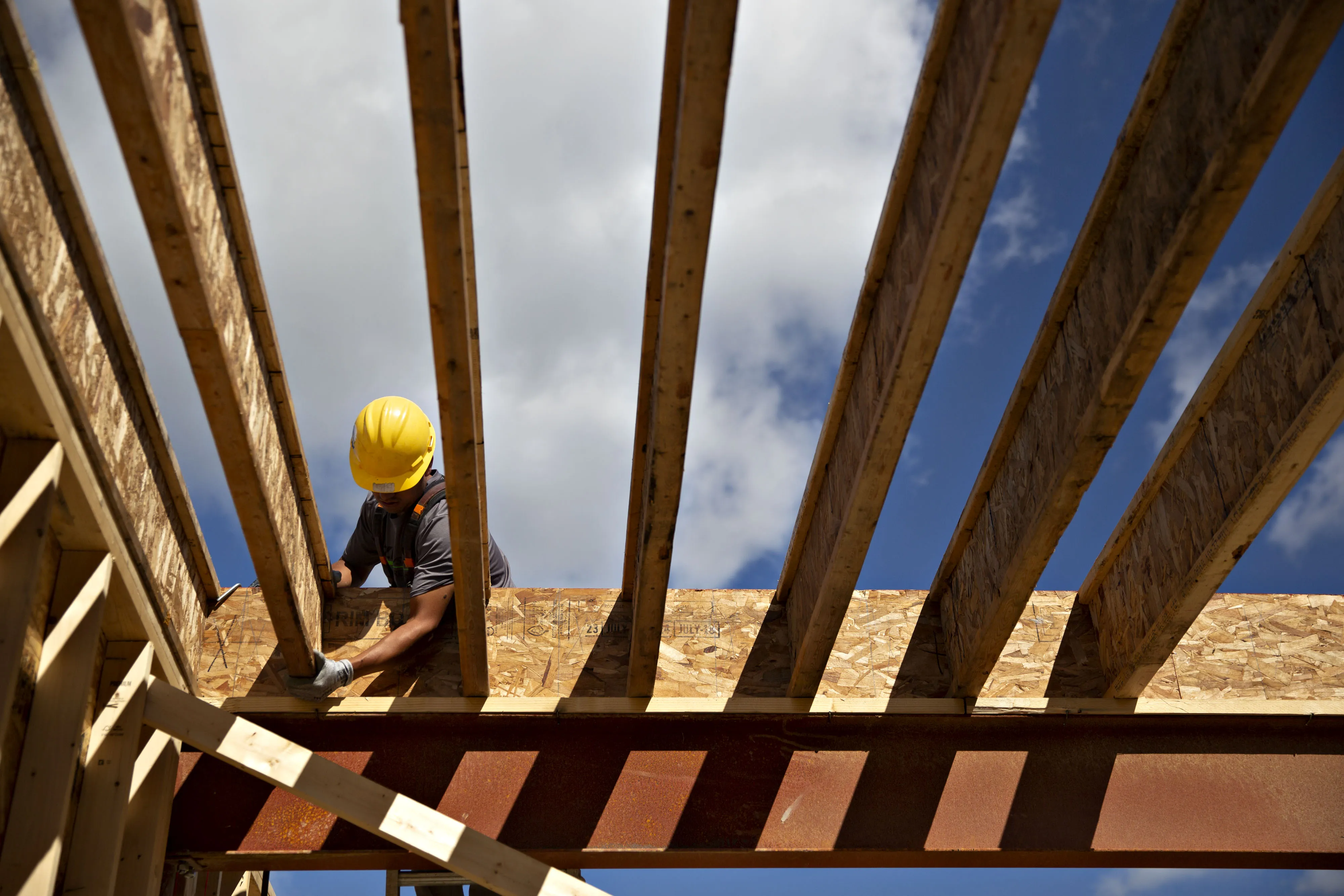 A contractor adjusts a floor joist while working on a home under construction in Elgin, Illinois.