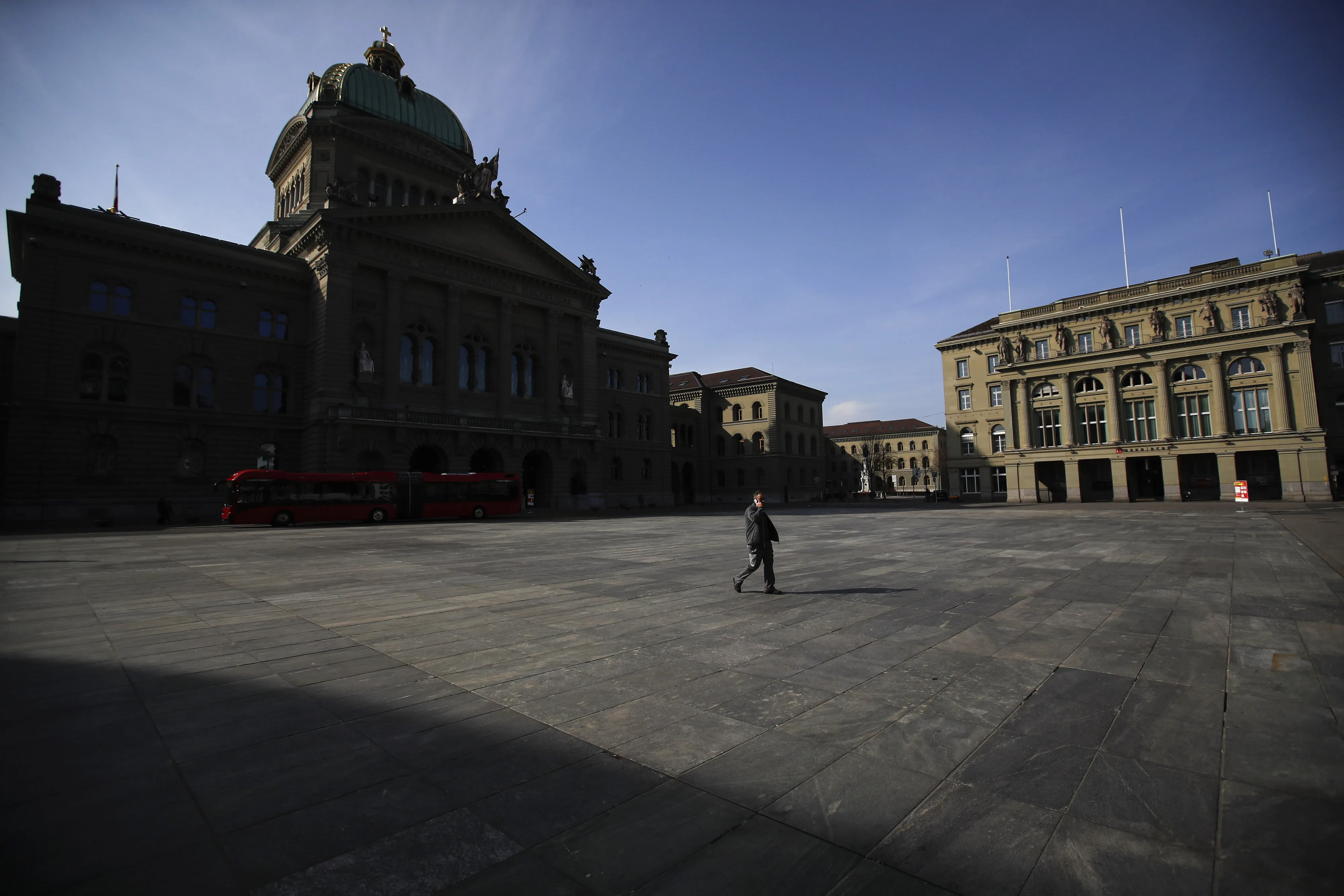 A pedestrian walks near the&nbsp;Federal Palace and the headquarters of the Swiss National Bank&nbsp;in Bern on March 27.
