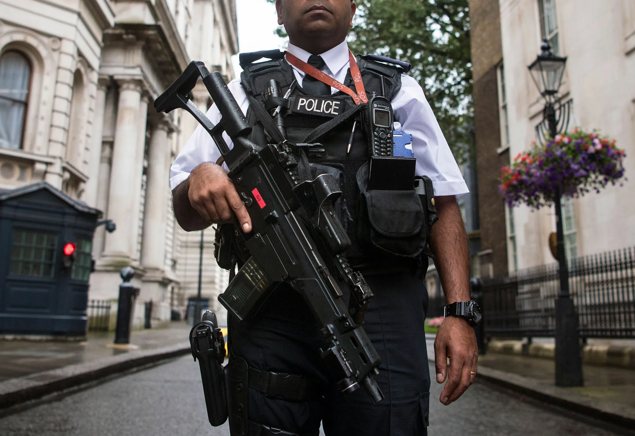 An armed Police officer patrols Downing Street in London on Aug. 3.
