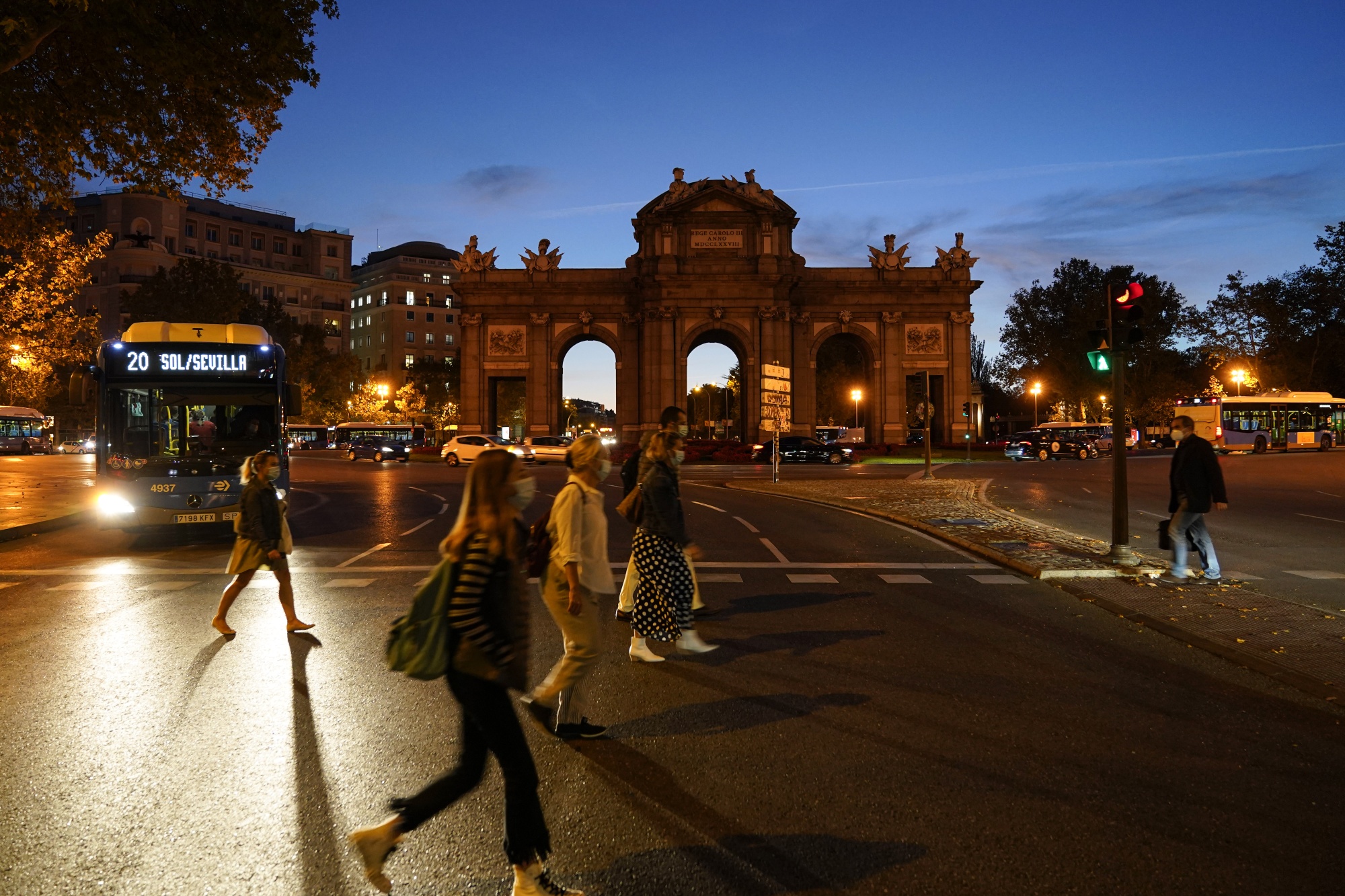 Morning commuters cross&nbsp;in front of the Puerta de Alcala monument in Madrid, Spain.