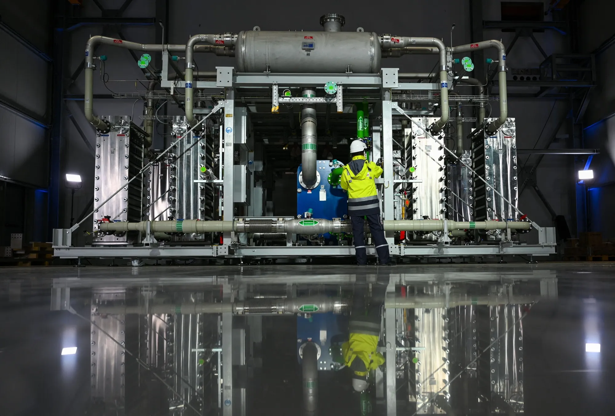 An employee&nbsp;stands in front of an electrolyzer at a&nbsp;hydrogen production facility of renewable hydrogen in Oberhausen, Germany.