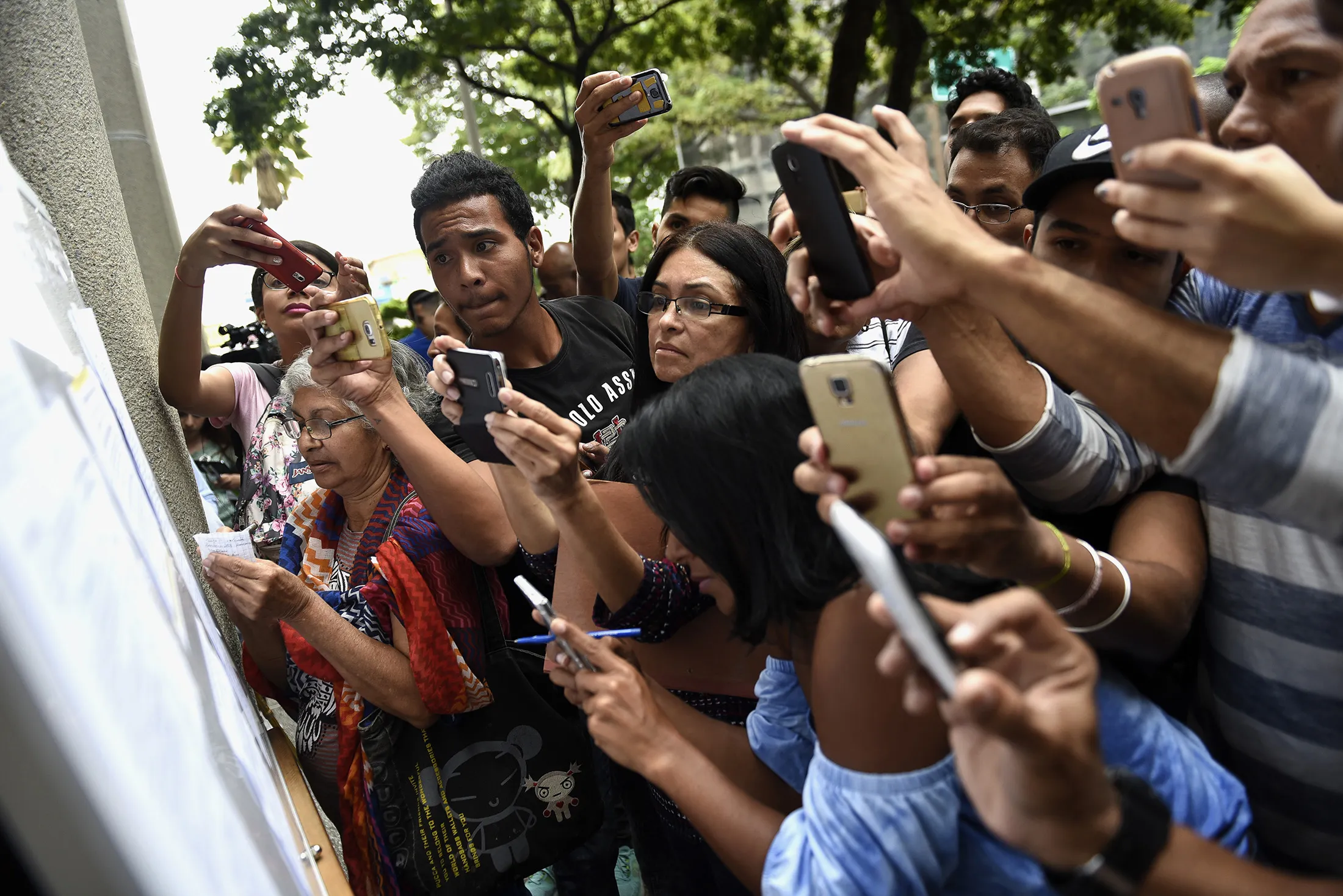Residents photograph a list of requirements needed to obtain Chilean visa.