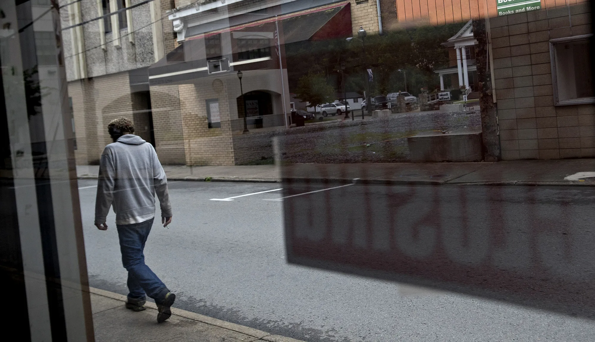 A pedestrian passes in front of a shuttered&nbsp;store in Logan, West Virginia.