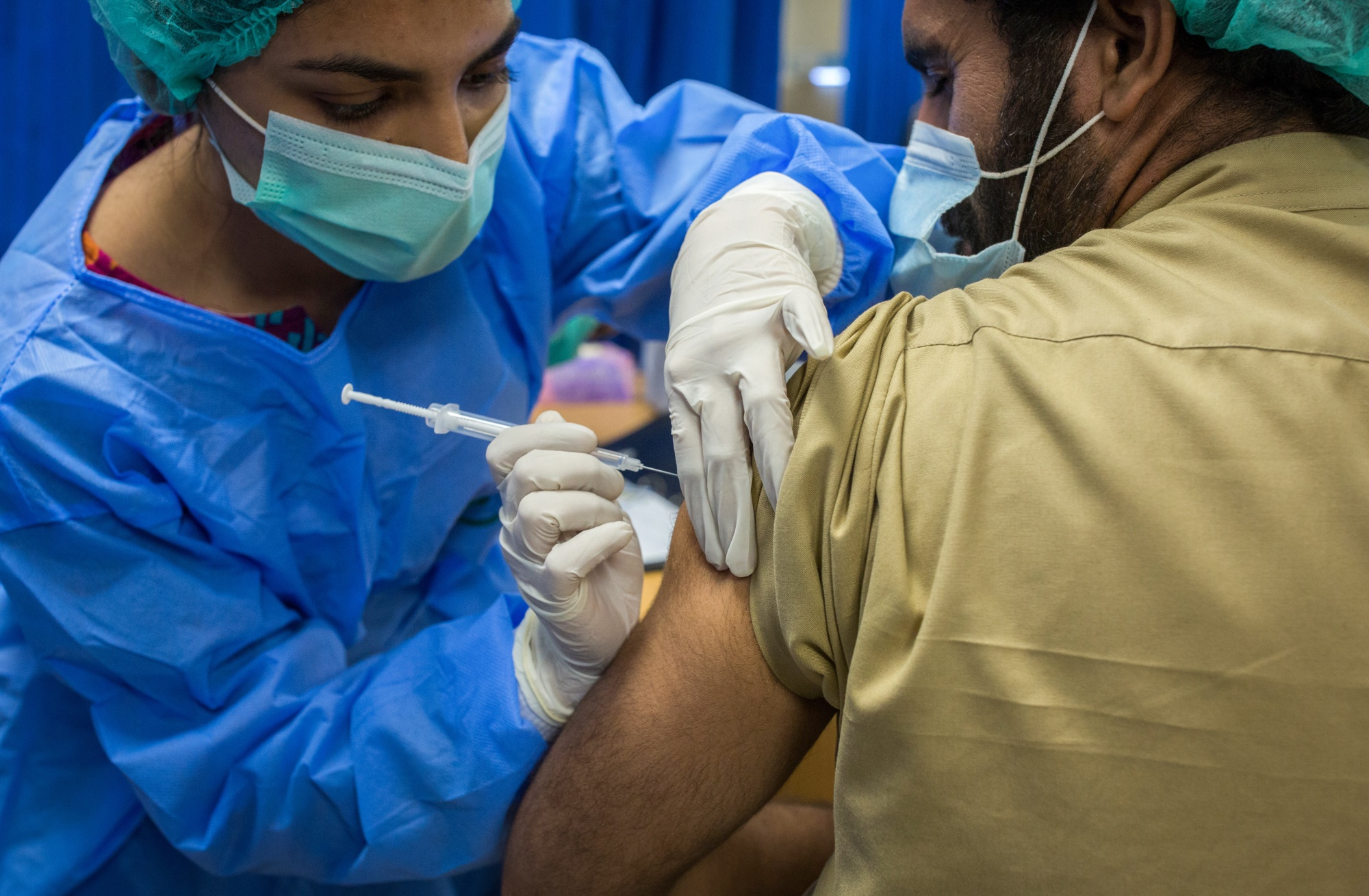 A health worker administers a dose of the Sinopharm Group Co. Covid-19 vaccine to a colleague in Karachi, on Feb. 3.