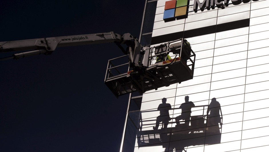 Workers install the Microsoft logo in Espoo, Finland in April 2014. 