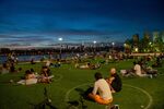People sit in circles to observe social distancing in Domino Park in Brooklyn, with a view of the Manhattan skyline, on July 26, 2020.