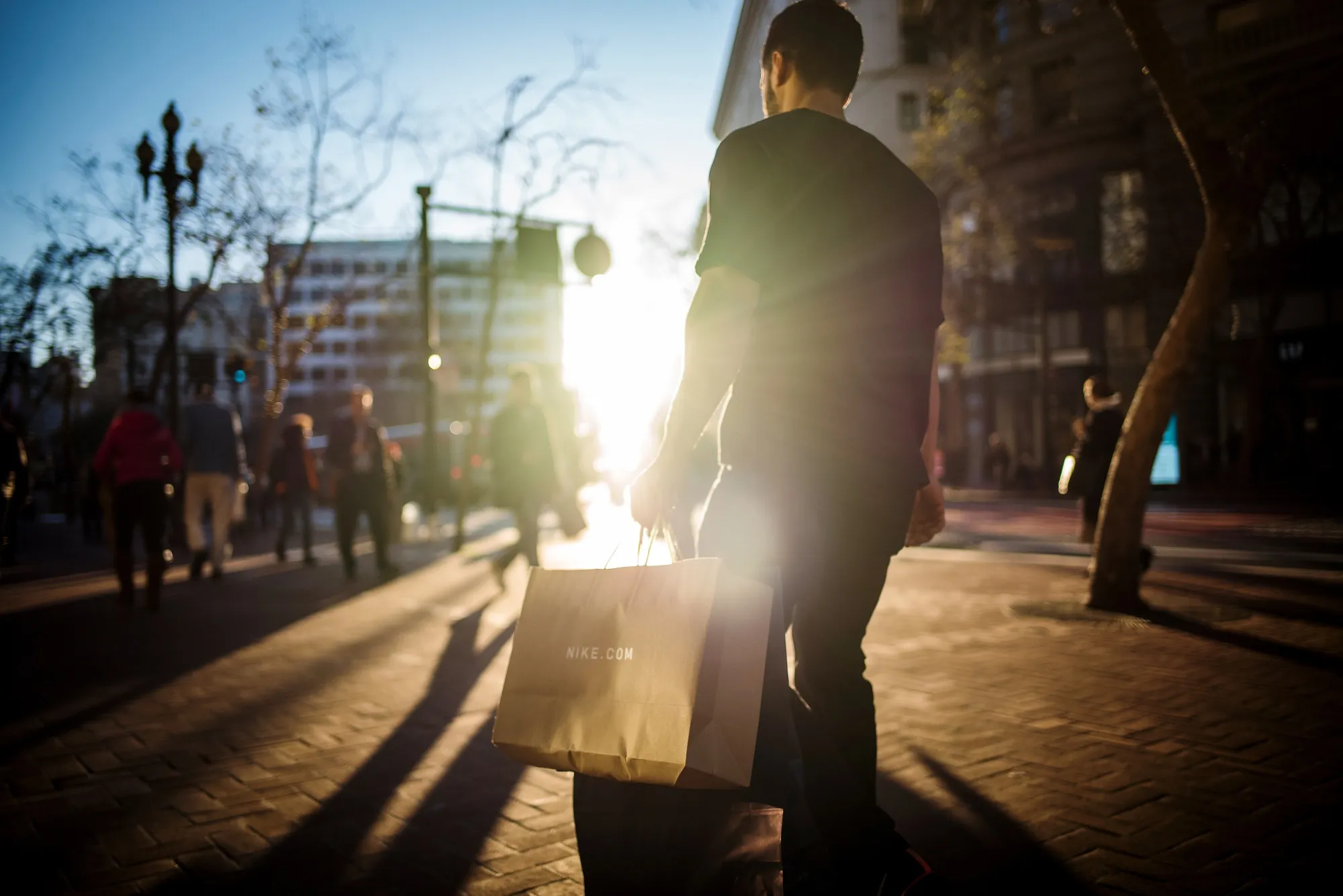 A pedestrian carries a Nike Inc. shopping bag in San Francisco, California, U.S., on Monday, March 11, 2019. Bloomberg is scheduled to release consumer comfort figures on March 14.