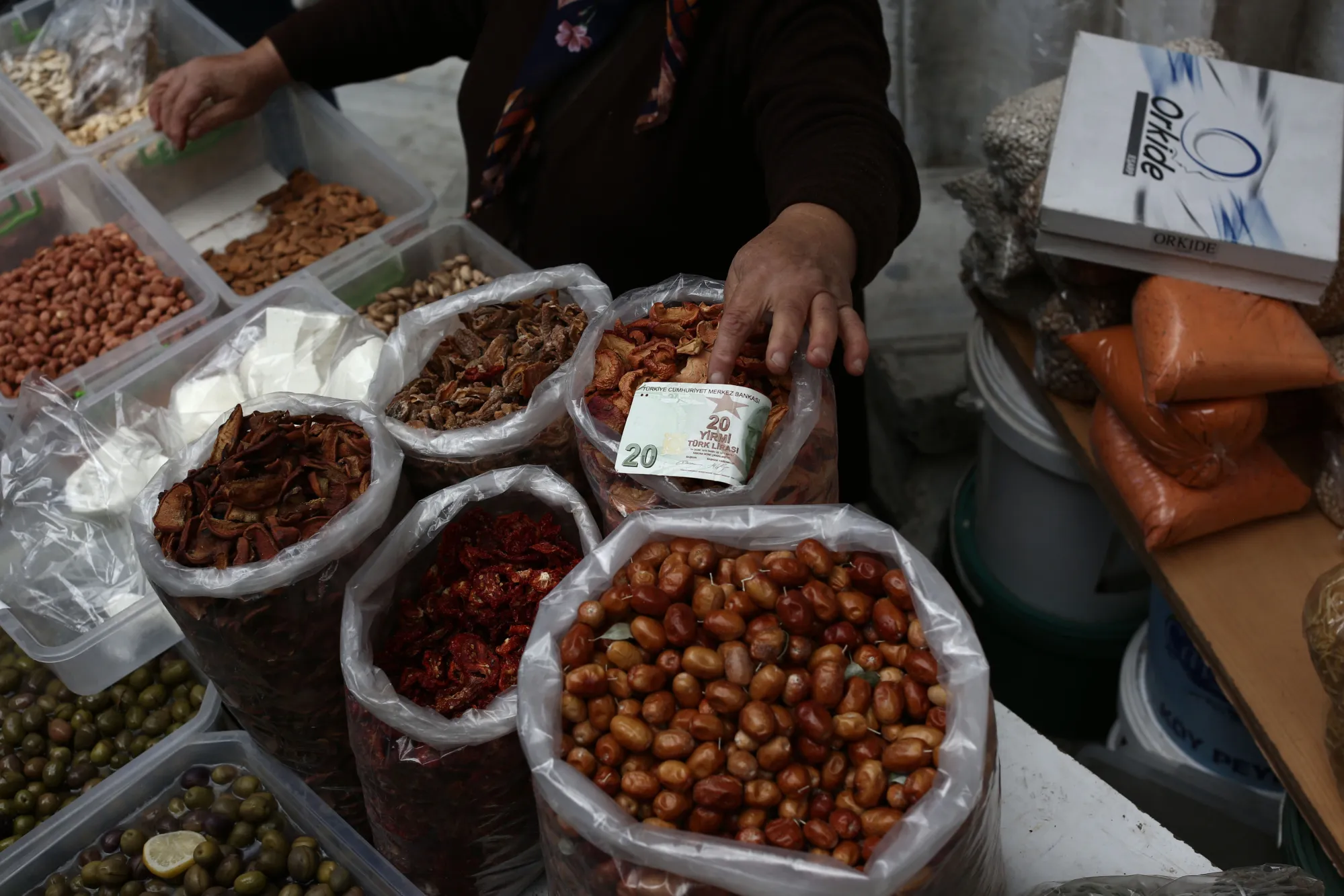 A market trader handles a 20 lira banknote on her food stall in Istanbul.