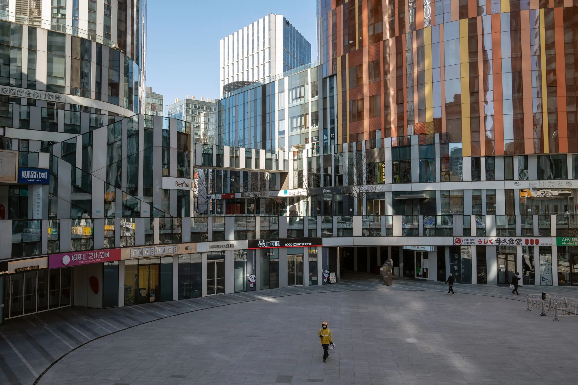 A delivery worker walks in an empty shopping area in Beijing, on Dec. 23.