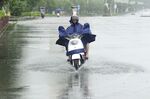 In this photo released by Xinhua News Agency, people ride a bike in the rain in Hezhou, southern China's Guangxi Zhuang Autonomous Region, Sunday, July 3, 2022. Chaba, the third typhoon of the year, made its landfall in the coastal area of Maoming City in south China's Guangdong Province on Saturday. (Liao Zuping/Xinhua via AP)