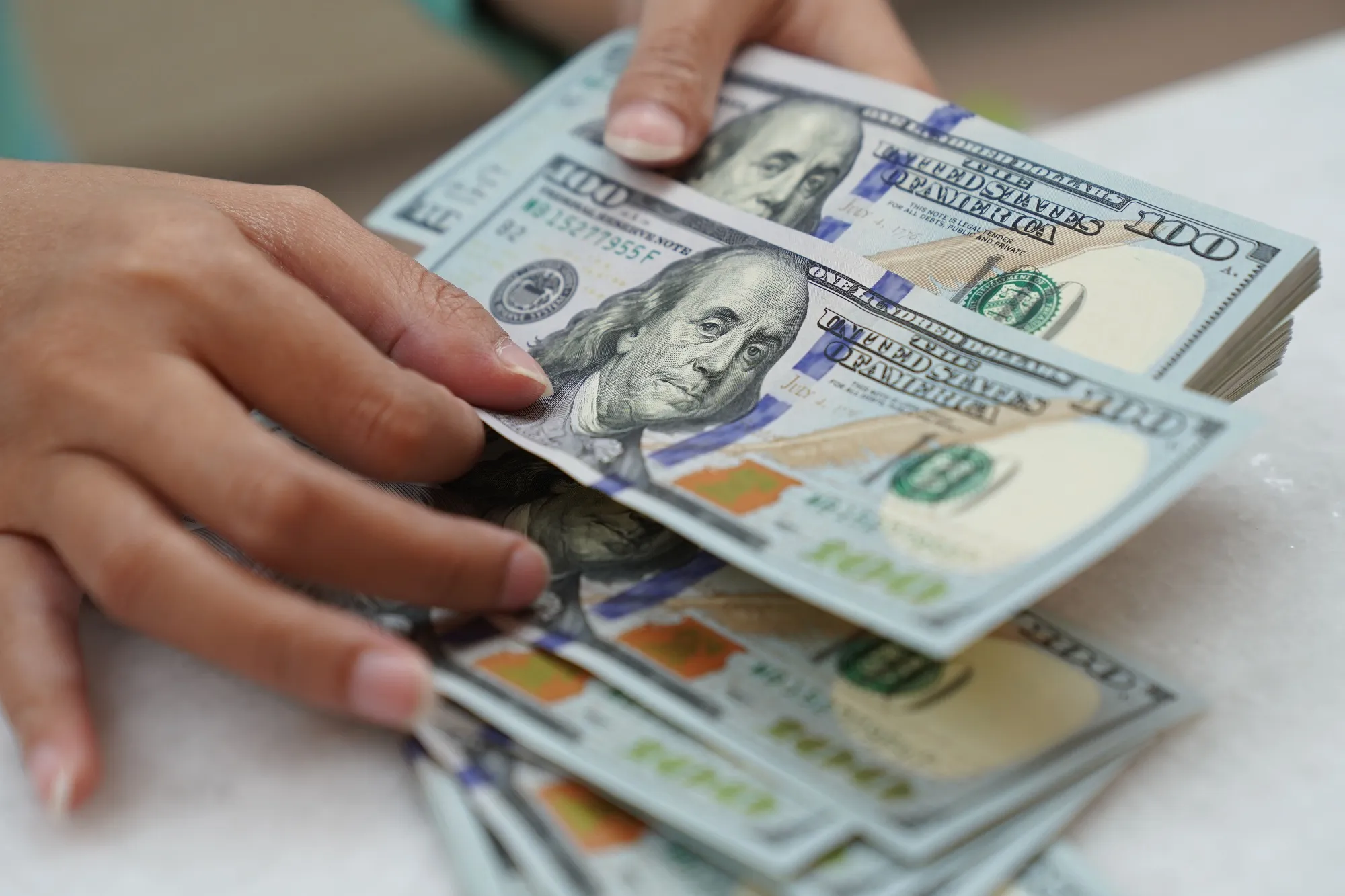 A worker counts U.S. dollar banknotes at a currency exchange office.