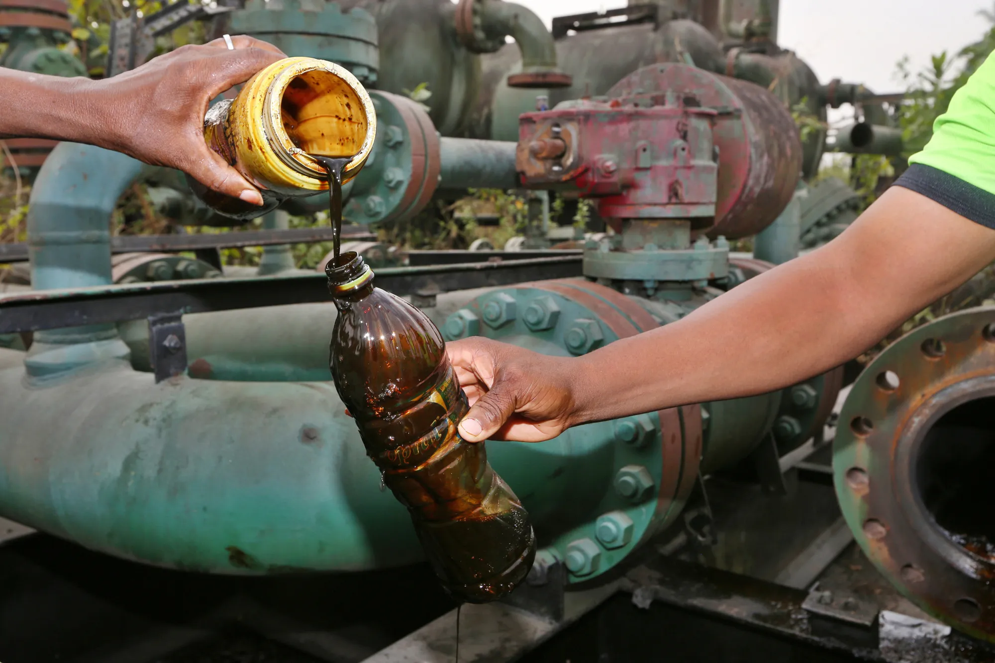 Locals pour containers of oil collected from an abandoned oil flow station operated by Royal Dutch Shell Plc in K-Dare, Nigeria, on Wednesday, Jan. 13, 2016. Twenty years after the oil-pollution crisis in the Niger delta shot to world attention when the then military government hanged the author and environmentalist, Ken Saro-Wiwa, residents in the region are seething with anger again that the problem hasn’t been fixed.