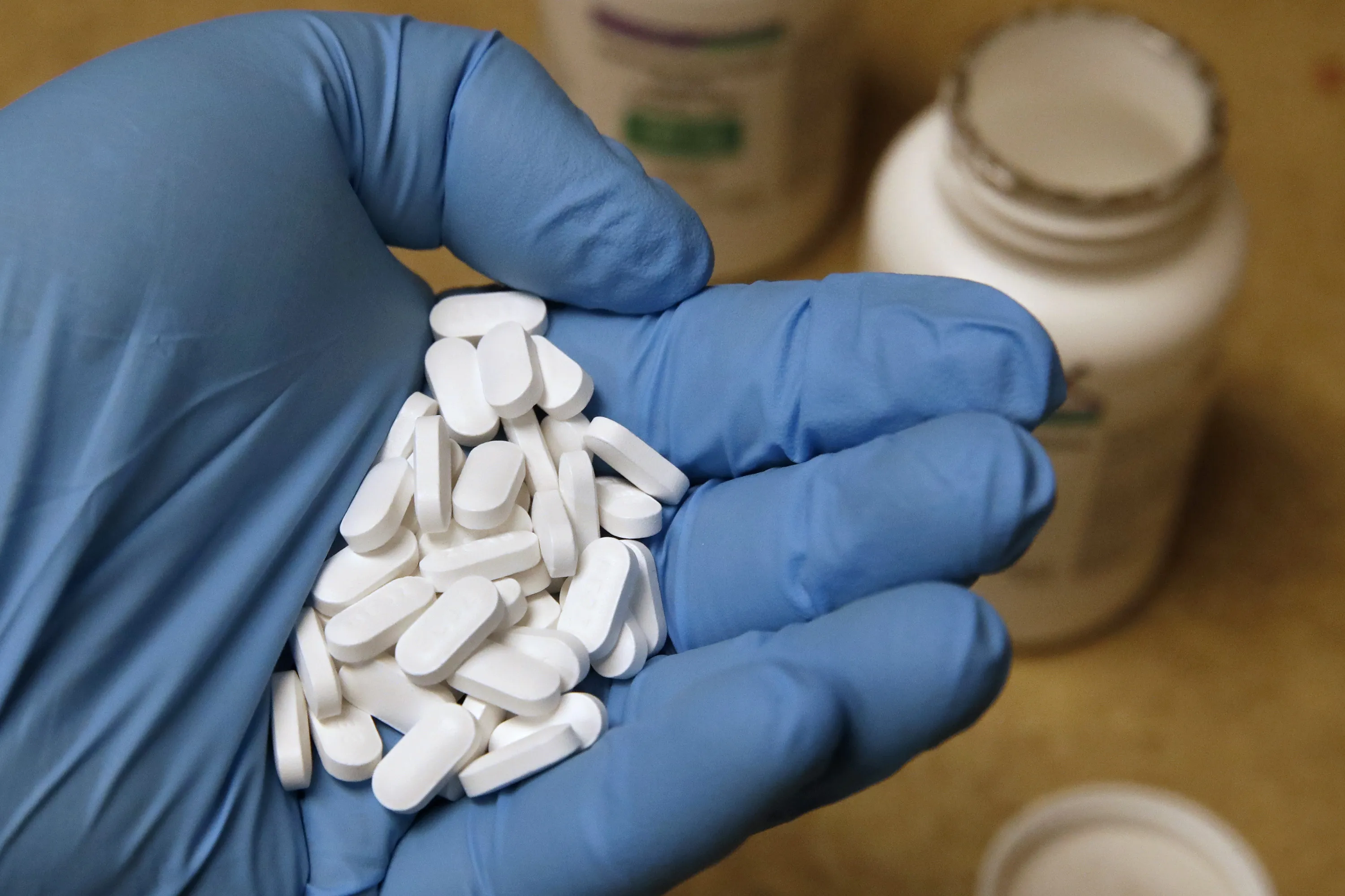 A pharmacy tech holds pills of Hydroxychloroquine.