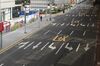 A pedestrian walks on the sidewalk of a deserted road in Shanghai, China, on Monday Feb. 3, 2020. 