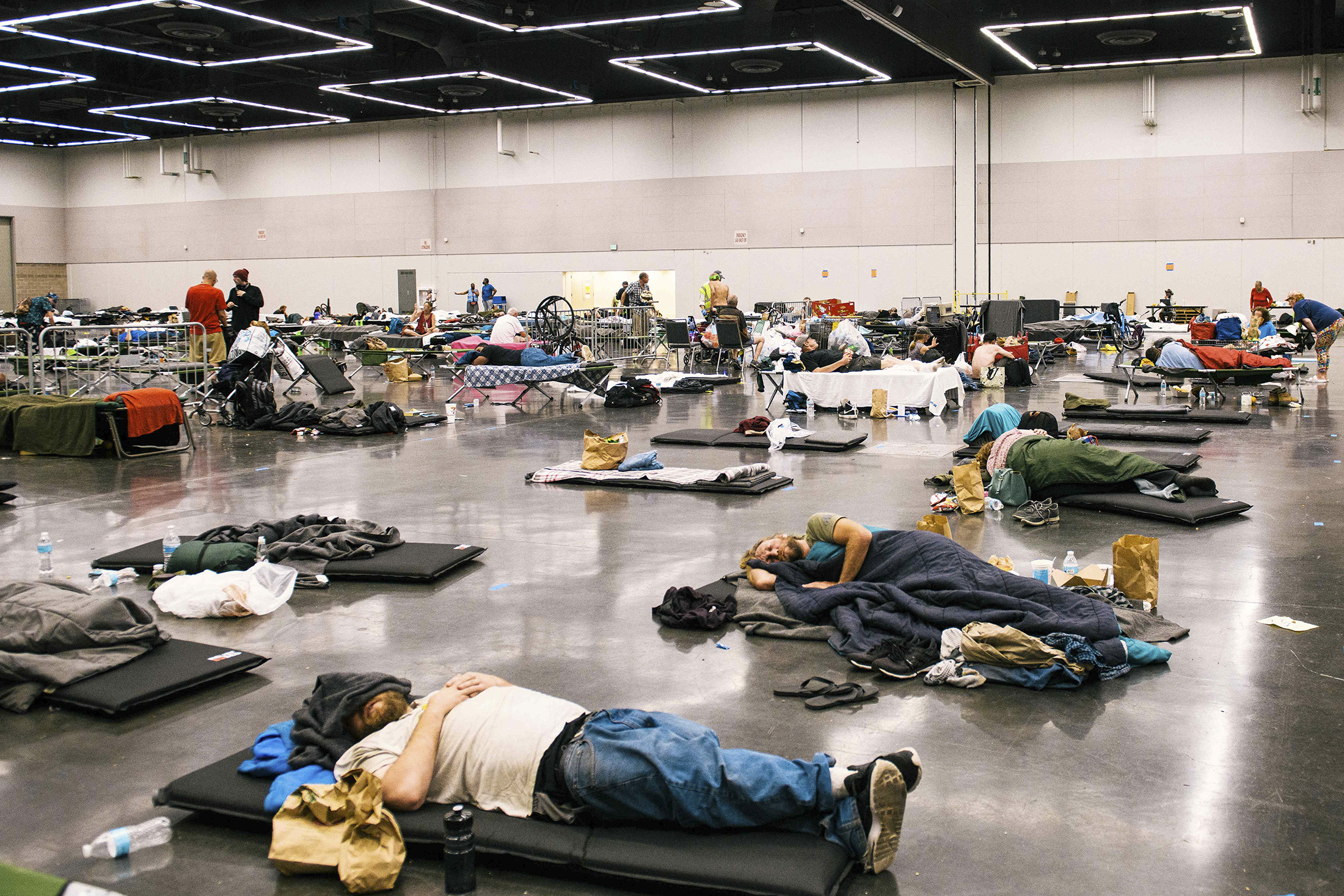 People rest at the Oregon Convention Center cooling station in Portland on June 28, 2021, after swathes of the U.S.&nbsp;and Canada endured record-setting heat that lead to deaths of hundreds of people.