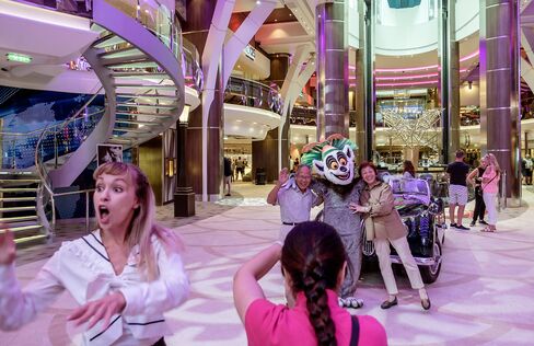 Spread over 18 decks and seven "neighborhoods"—connected by 24 elevators—the Oasis-Class Harmony of the Seas is capable of accommodating close to 9,000 passengers and crew. Here, guests have souvenir photos taken in the Royal Promenade neighborhood.