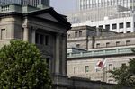 A Japanese national flag flies outside the Bank of Japan (BOJ) headquarters in Tokyo, Japan, on Monday, Sept. 14, 2020.