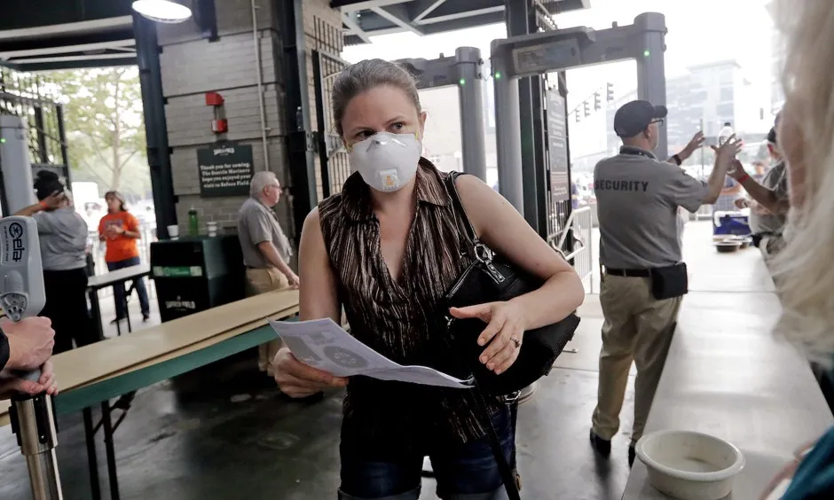 A fan enters the Seattle Mariners ballpark wearing a mask to help protect against smoky skies before a baseball game in Seattle in August 2018.
