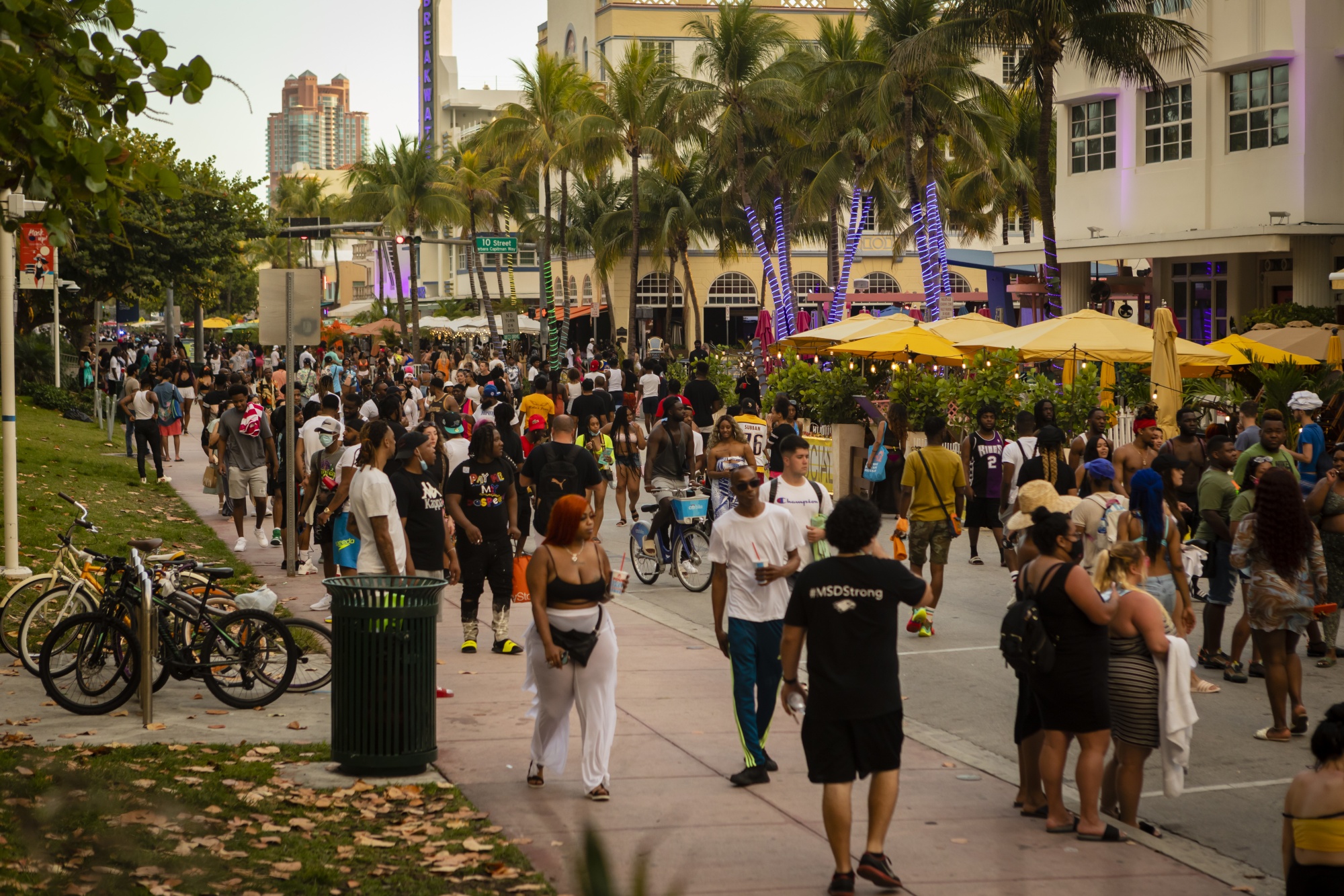 A crowd of people walk along Ocean Drive in the South Beach neighborhood of Miami, Florida.