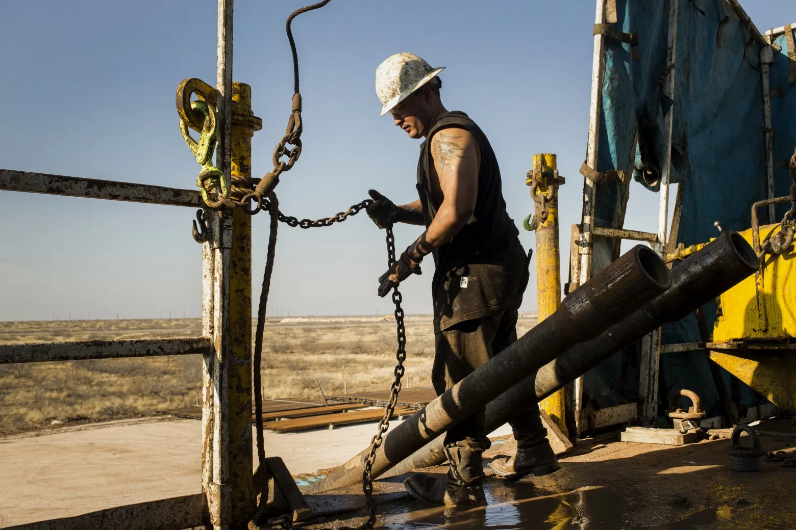 A worker prepares to lift drills by pulley at the&nbsp;Big Dog Drilling Rig 22&nbsp;in the Permian Basin.