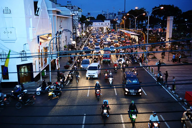Traffic moves along a road during rush hour at dusk in Bandung, West Java province, Indonesia, on Monday, April 27, 2015. The rupiah completed its biggest weekly drop since March after data showed Indonesia’s economy shrank for a second straight quarter and the government clashed with the central bank over interest-rate policy.
