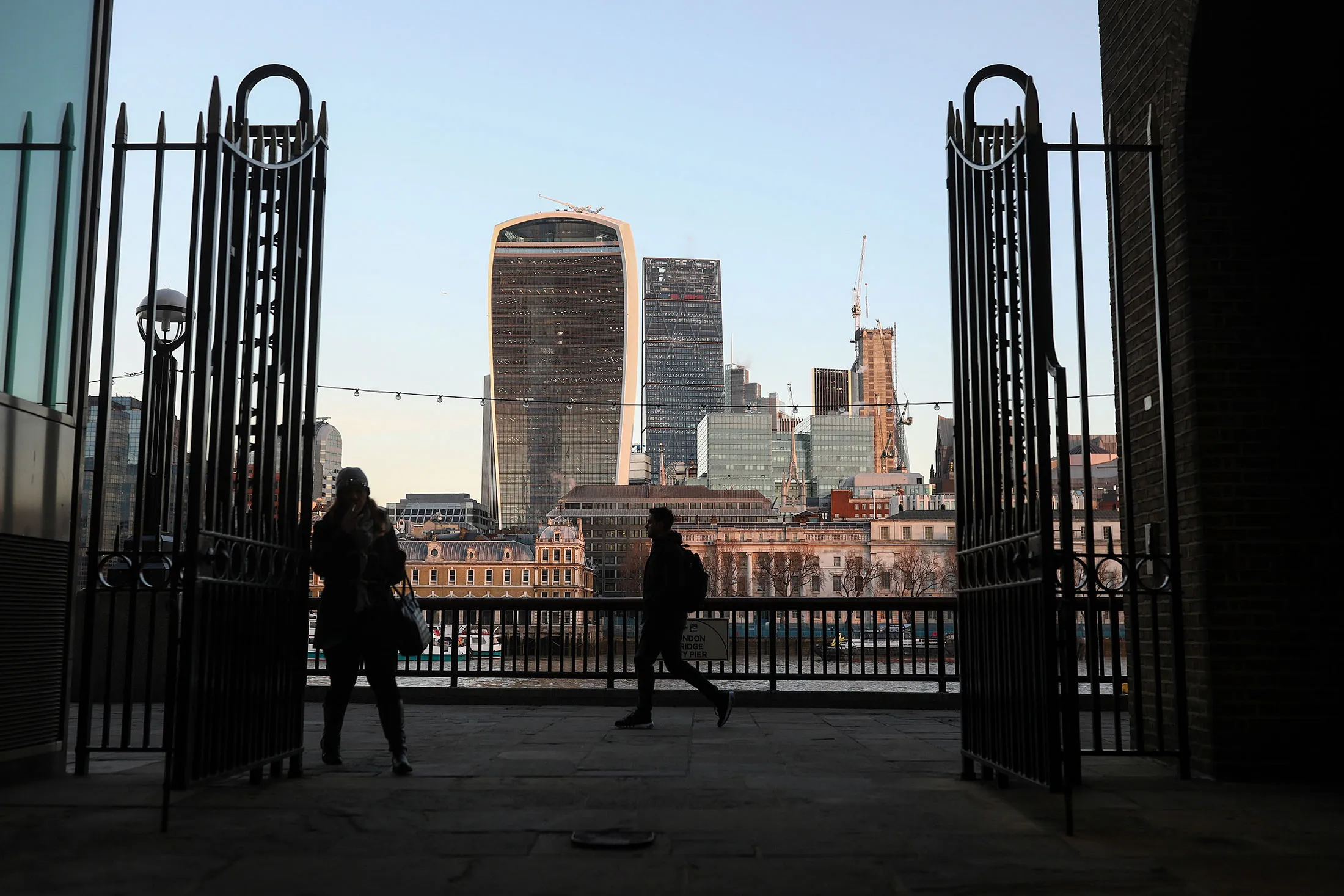 Pedestrians walk past a view of 20 Fenchurch Street, also known as the 'Walkie-Talkie,' in London, U.K., on Thursday, Jan. 5, 2017.
