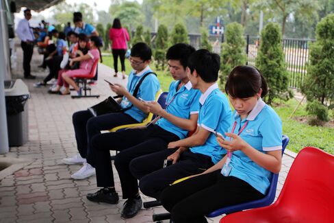 Workers wait to depart work via company buses.