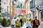 Pedestrians walk down a shopping street in Stockholm, Sweden.