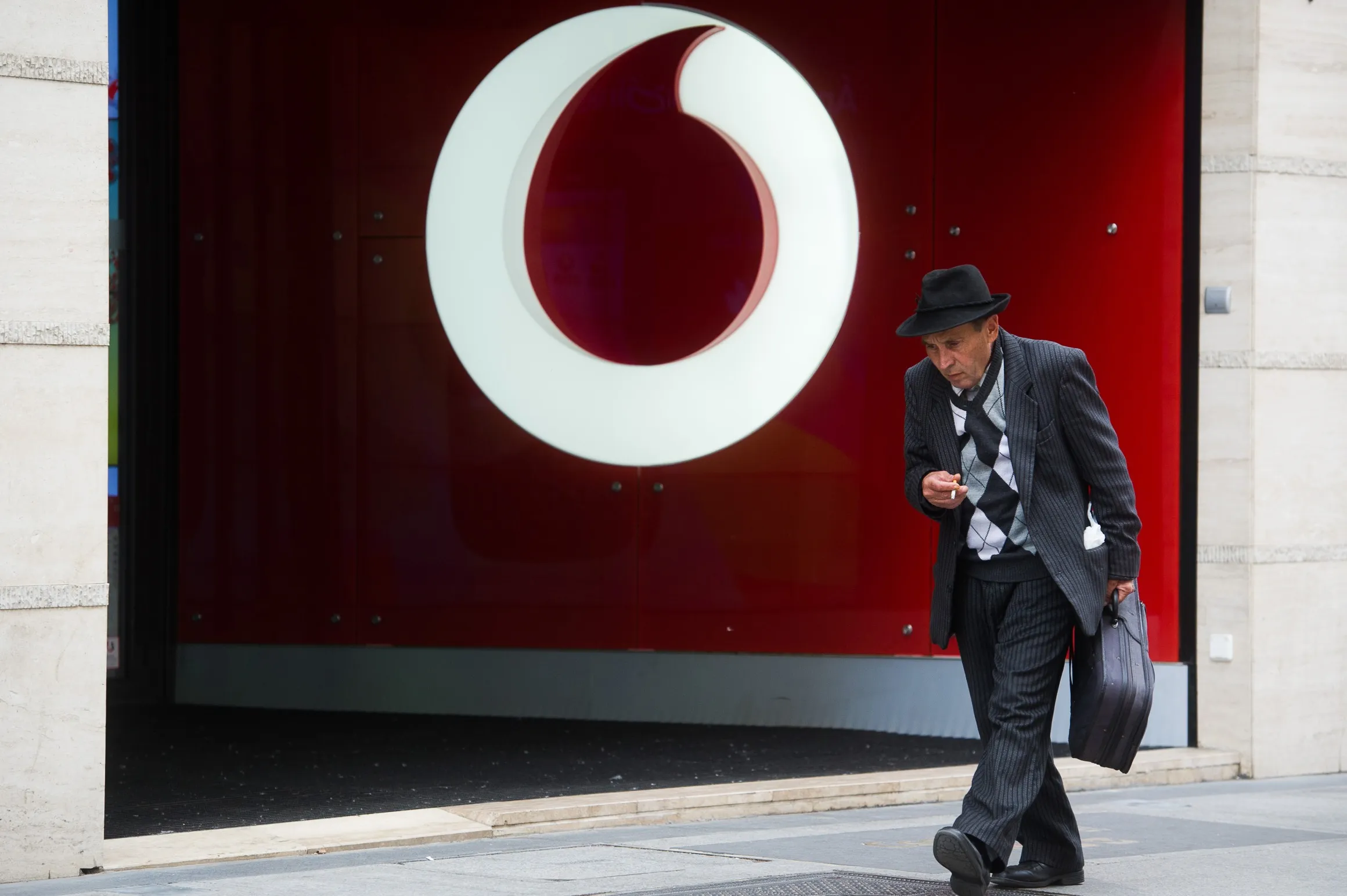 A pedestrian passes a Vodafone Group Plc communications store in Budapest.