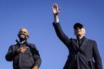 Former U.S. President Barack Obama and Democratic presidential nominee Joe Biden wave to the crowd at the end of a drive-in campaign rally at Northwestern High School on October 31, 2020 in Flint, Michigan. 