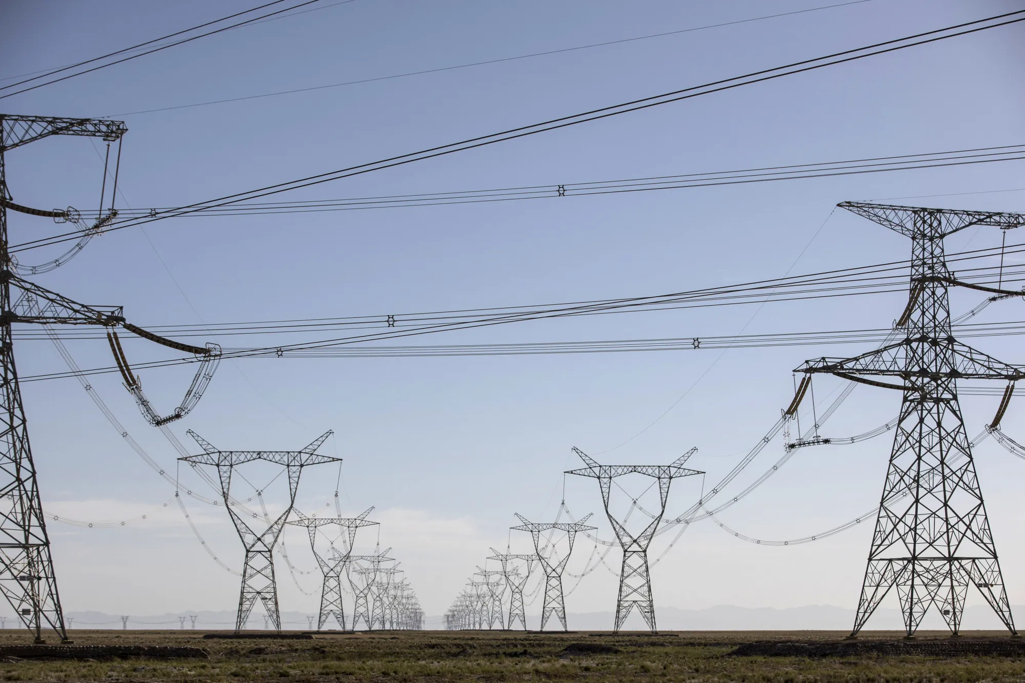 Power lines carrying electricity from the Golmud Solar Park hang from transmission towers on the outskirts of Golmud, Qinghai province.